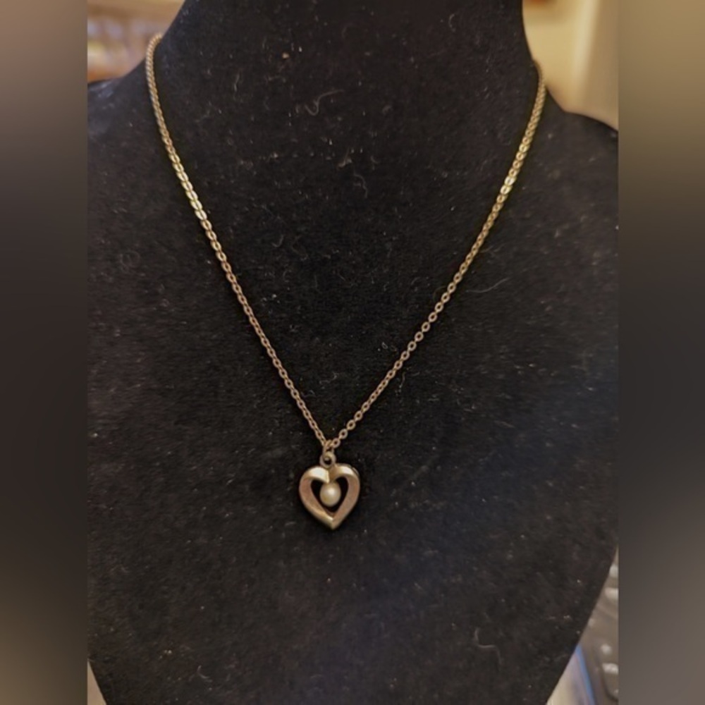 Golden necklace with heart shaped pendant with pearly bead center